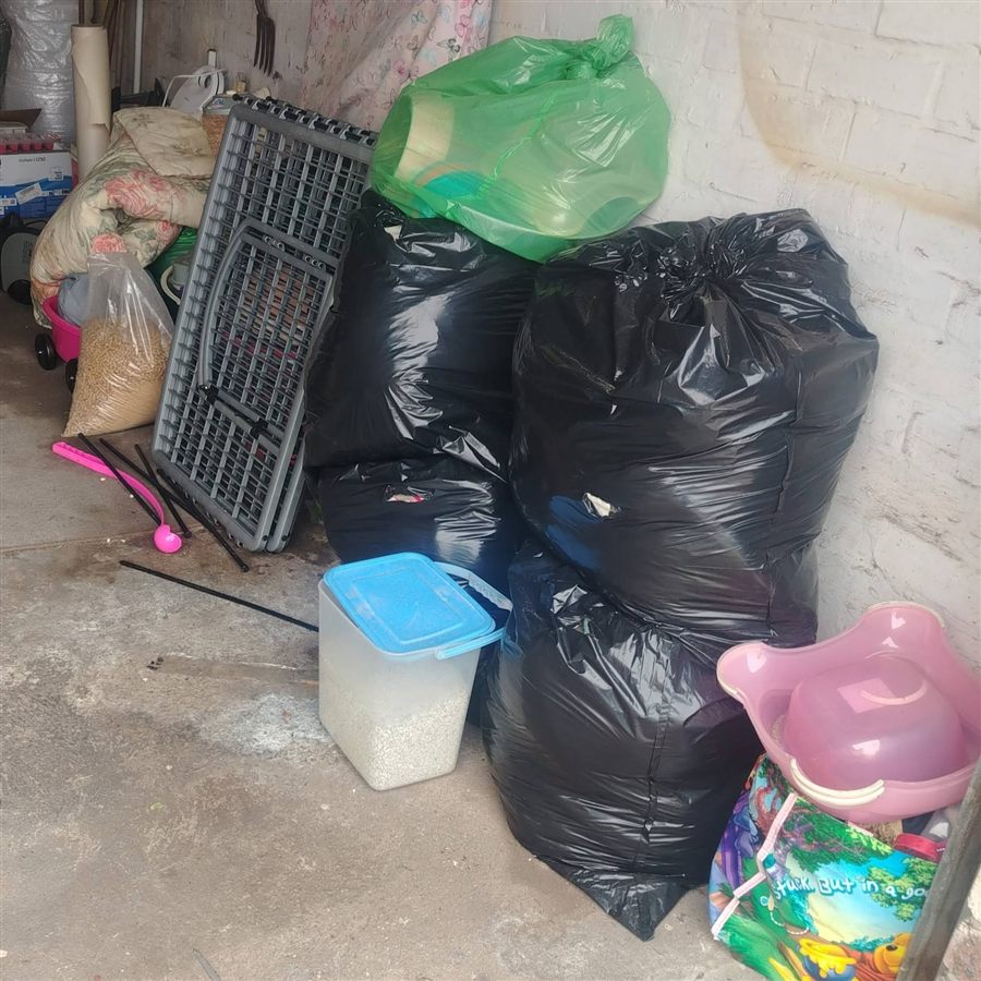 Bags, crates and boxes of cleared belongings stacked and ready to leave