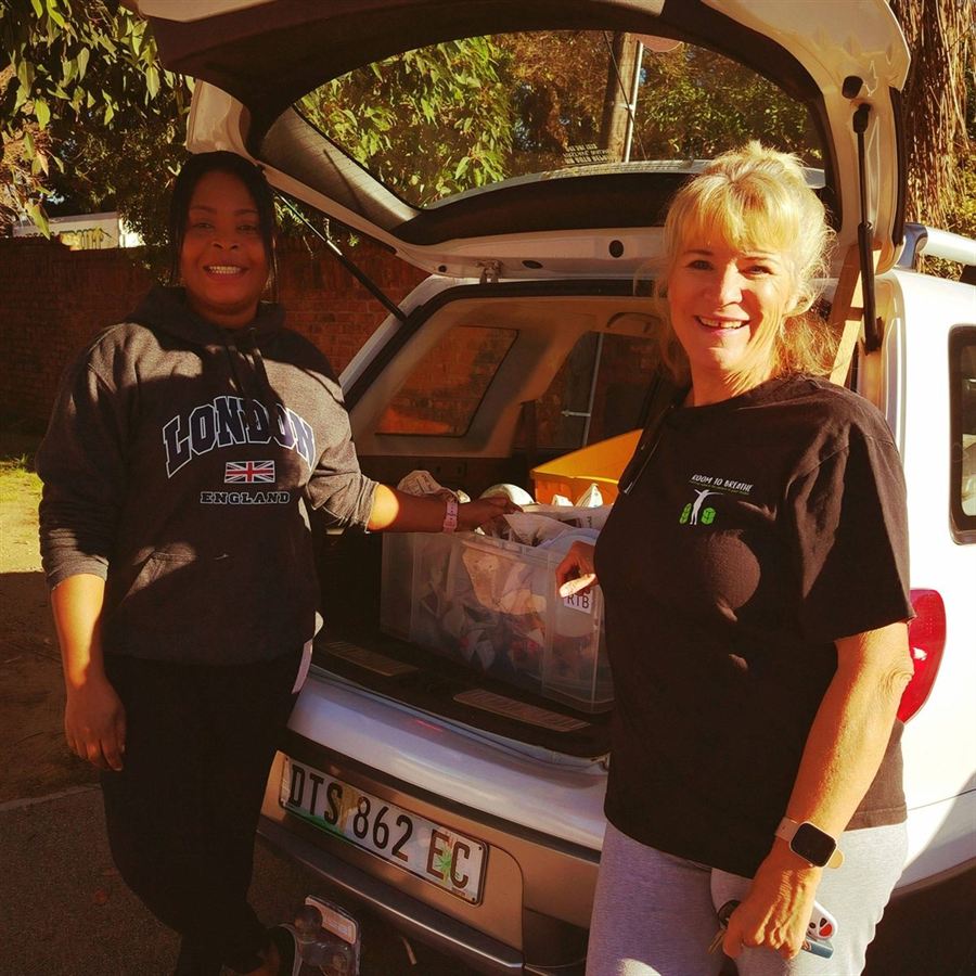 Robyn and a colleague loading good furniture and household items into a vehicle