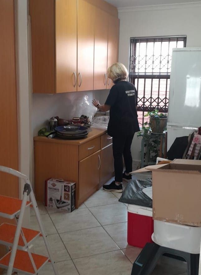 Robyn clearing and sorting a client's kitchen cupboards