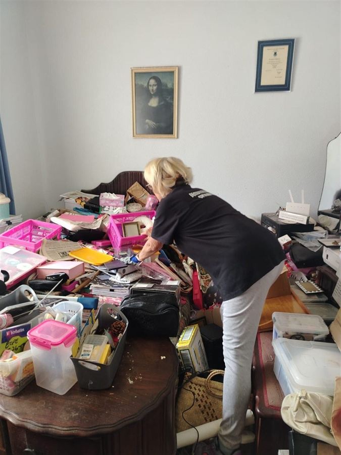 Robyn sorting through a client's belongings, room by room